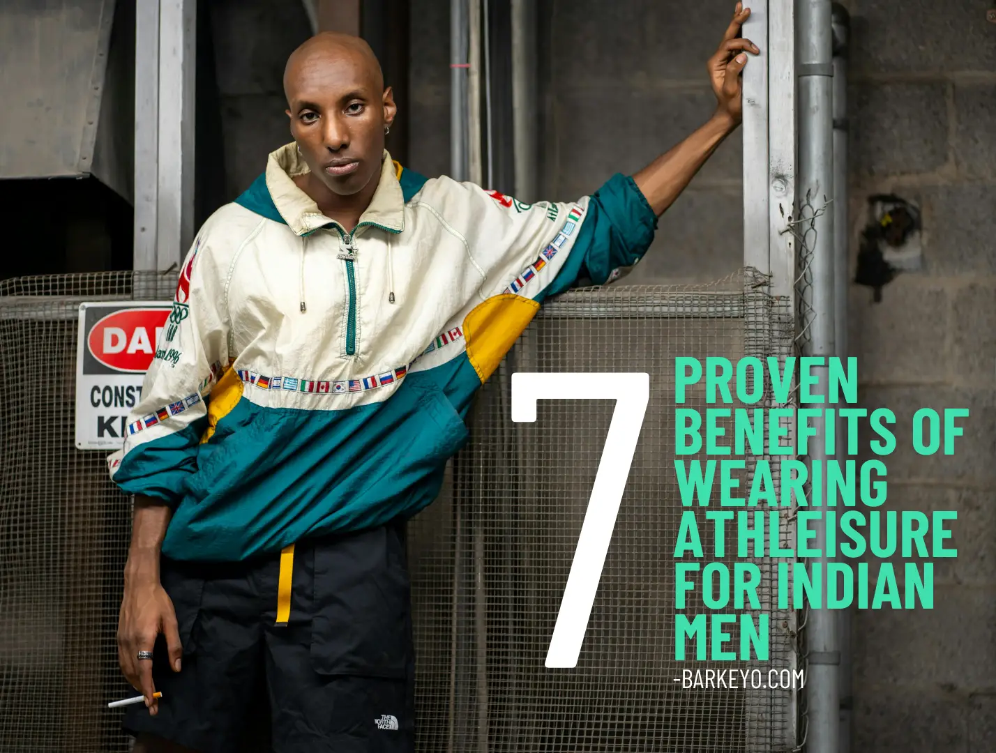 Man in stylish athleisure outfit standing against an industrial background with the text '7 Proven Benefits of Wearing Athleisure for Indian Men – Barkeyo.com